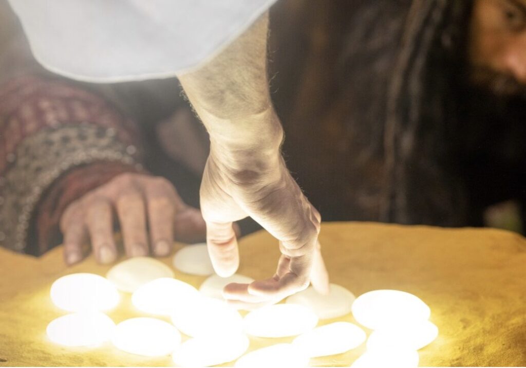 man's hand touching glowing stones